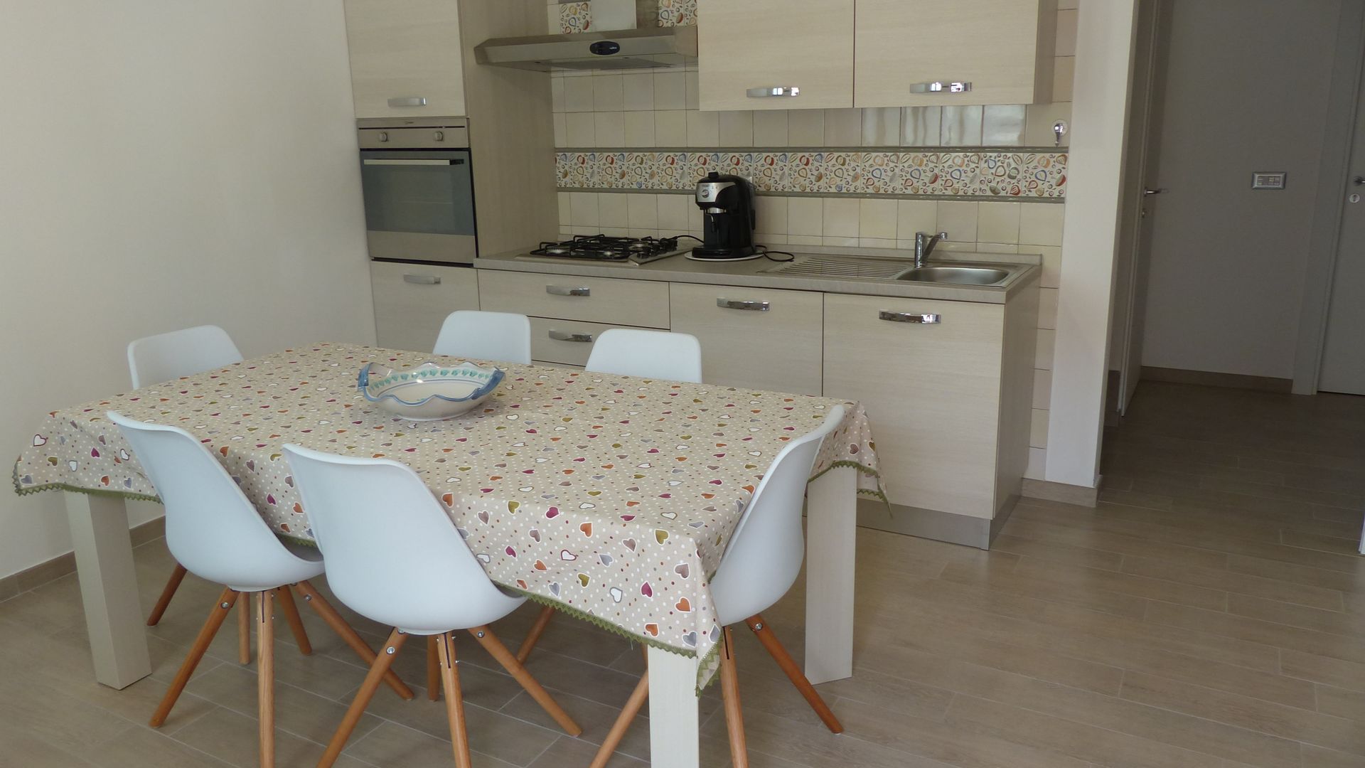 Sala comune con tavolo e angolo cottura