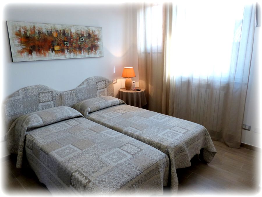 Camera Beige: letti singoli con luce calda